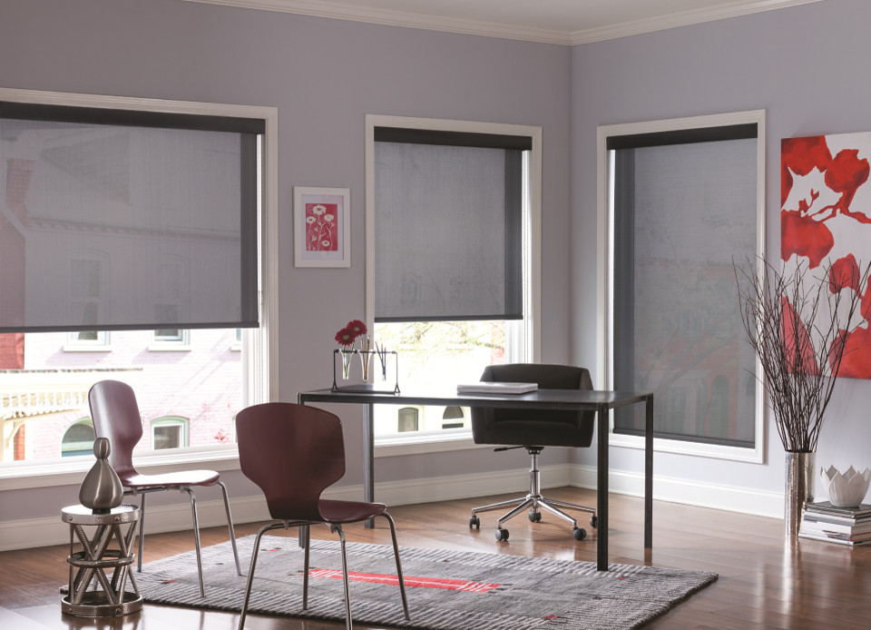 Modern inredning av ett mellanstort arbetsrum, med lila väggar, mörkt trägolv, ett fristående skrivbord och brunt golv