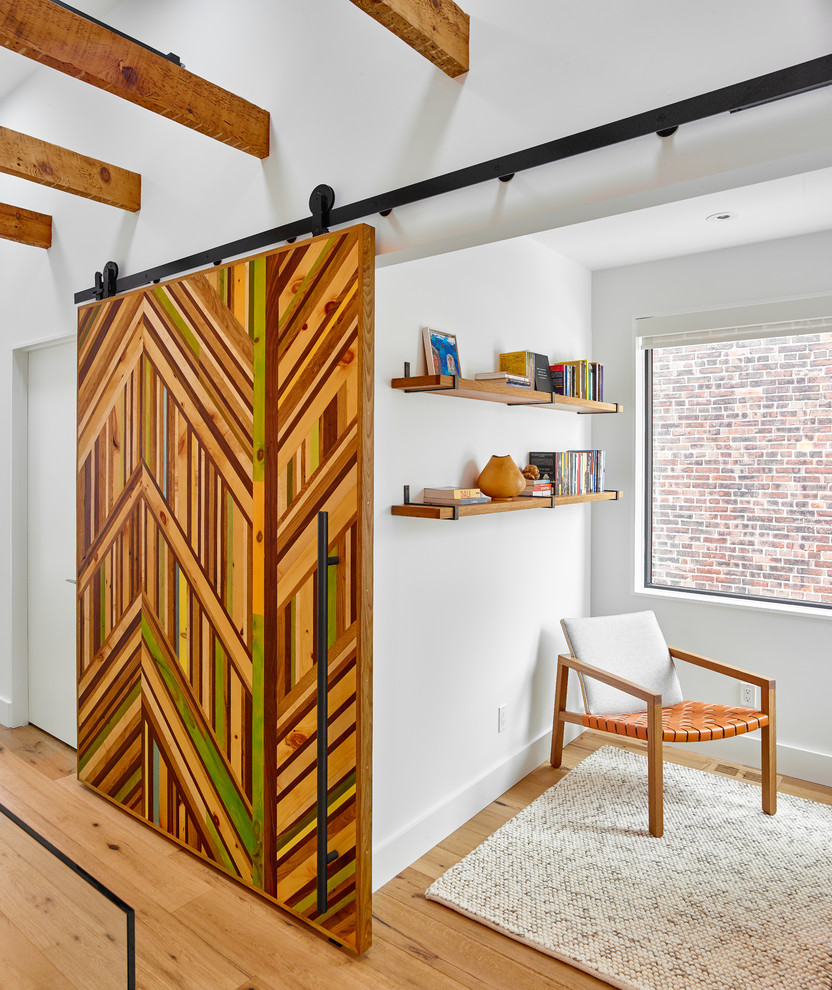 Idée de décoration pour un bureau design avec un mur blanc, un sol en bois brun et un sol marron.