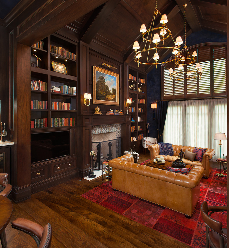 Inspiration för mycket stora klassiska arbetsrum, med blå väggar, mellanmörkt trägolv, en standard öppen spis, en spiselkrans i trä, ett inbyggt skrivbord, ett bibliotek och brunt golv