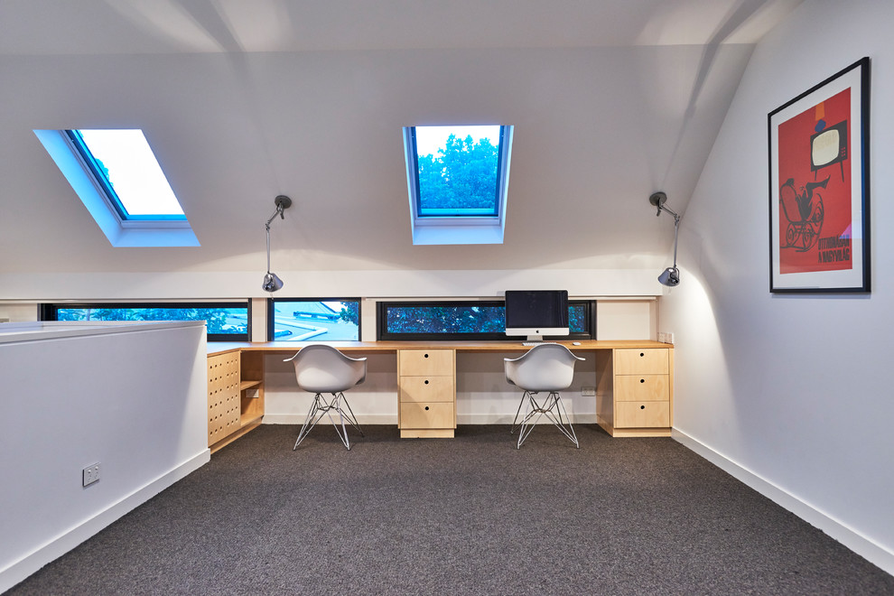 Modelo de despacho contemporáneo grande con paredes blancas, moqueta, escritorio empotrado y suelo negro