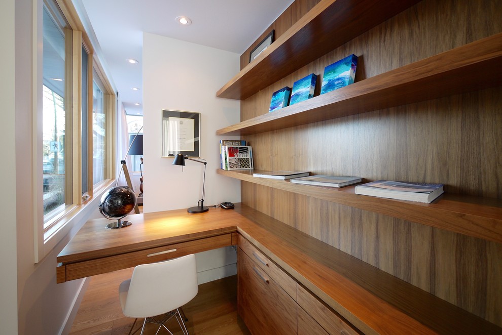 Cette photo montre un bureau rétro de taille moyenne avec un mur blanc, un sol en bois brun et un bureau intégré.