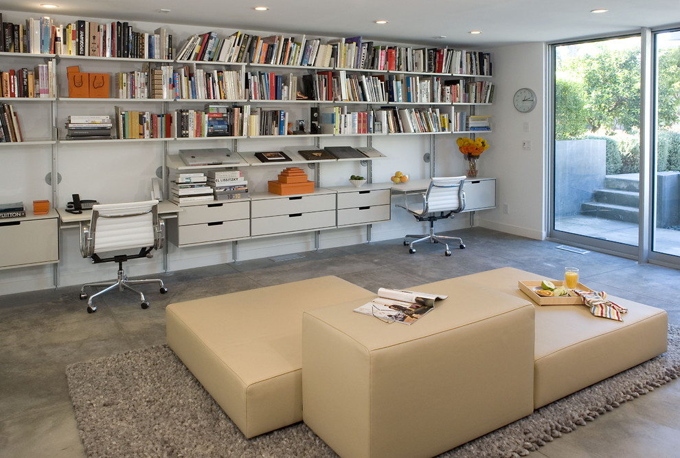 На фото: кабинет в стиле модернизм с белыми стенами и встроенным рабочим столом с