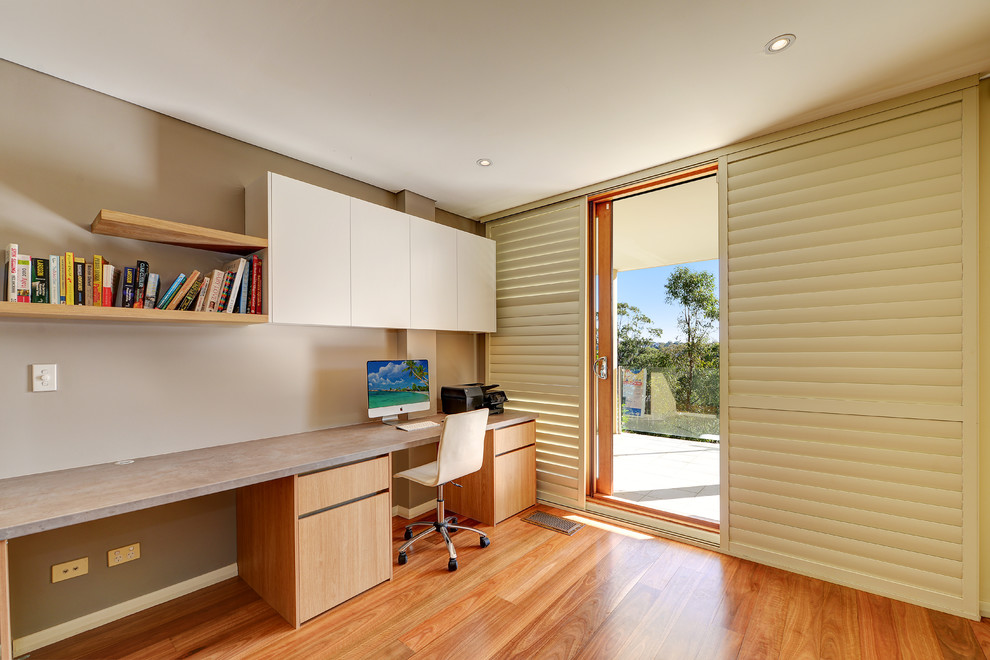 Foto di un ufficio design di medie dimensioni con pareti grigie, pavimento in legno massello medio, scrivania incassata e pavimento marrone