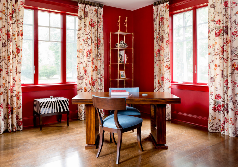 Klassisches Arbeitszimmer mit Arbeitsplatz, roter Wandfarbe, braunem Holzboden und freistehendem Schreibtisch in New York
