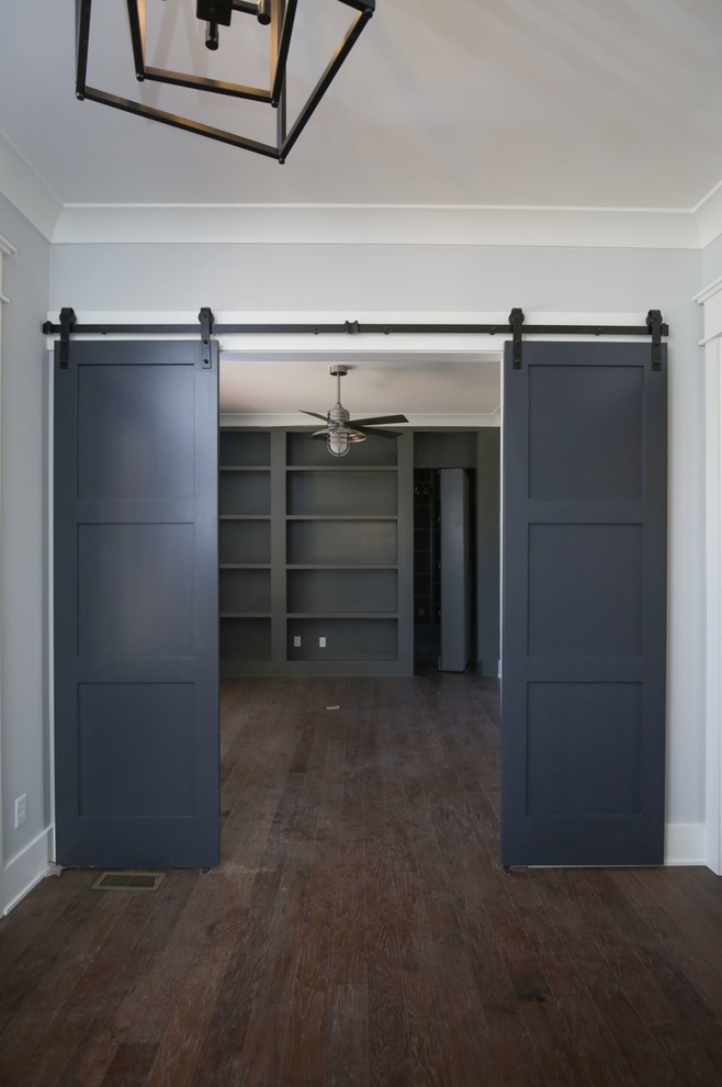 Imagen de despacho clásico renovado de tamaño medio sin chimenea con paredes grises, suelo de madera en tonos medios y suelo marrón
