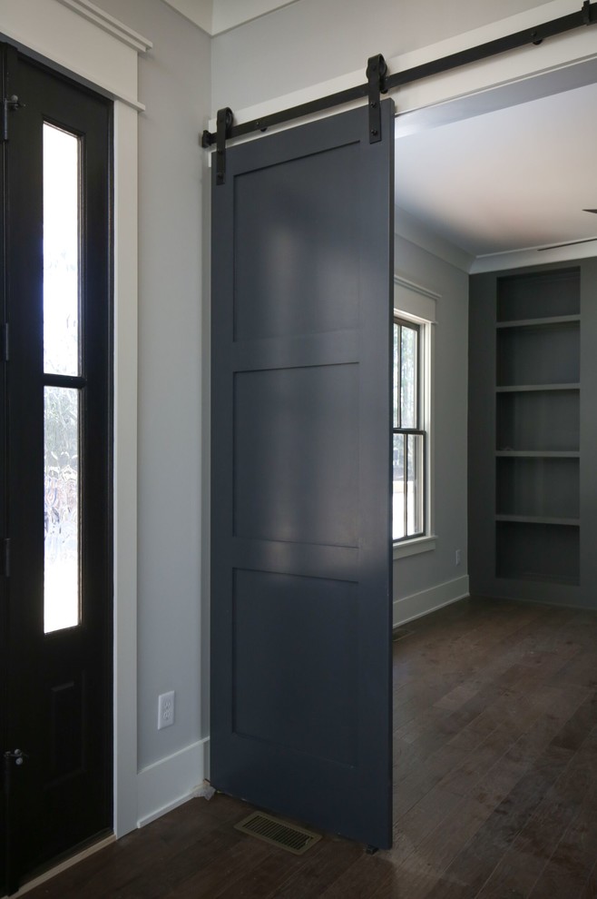 Example of a mid-sized transitional medium tone wood floor and brown floor study room design in Raleigh with gray walls and no fireplace