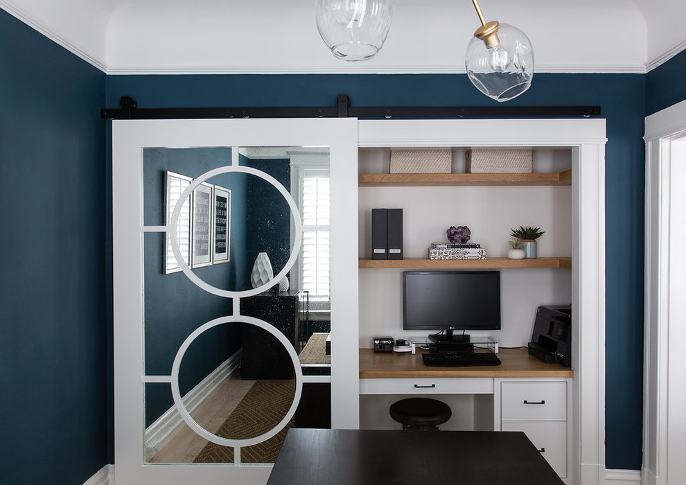 Exemple d'un bureau éclectique avec un bureau intégré et un mur bleu.