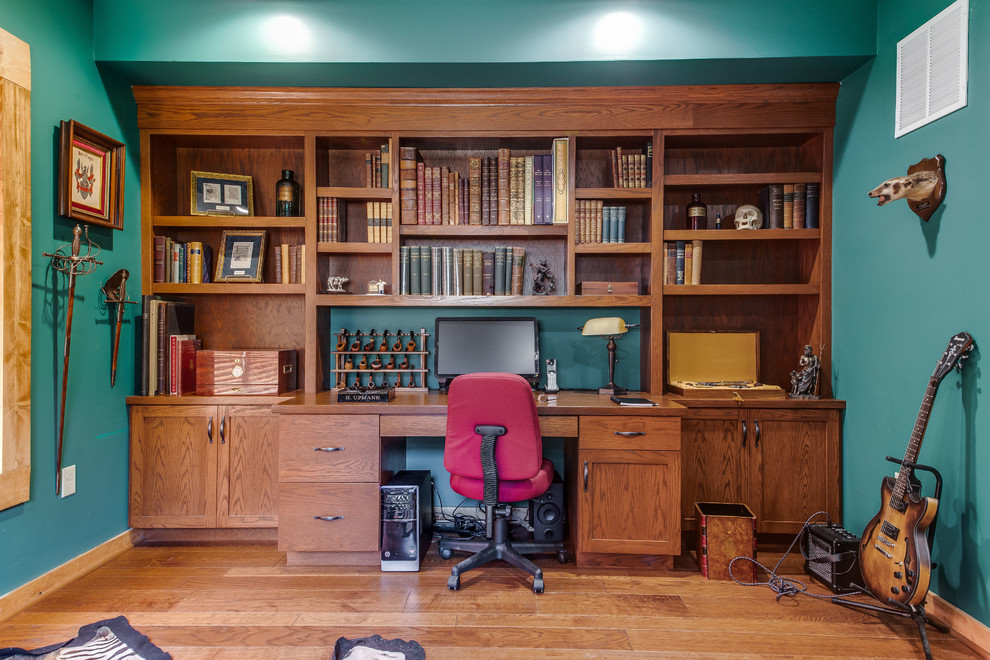На фото: кабинет в стиле рустика с синими стенами, паркетным полом среднего тона, встроенным рабочим столом и коричневым полом с