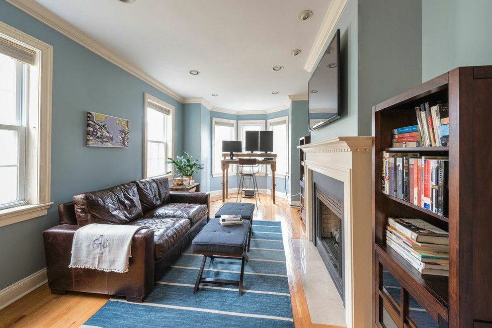 フィラデルフィアにある中くらいなラスティックスタイルのおしゃれなホームオフィス・書斎 (青い壁、無垢フローリング、標準型暖炉、木材の暖炉まわり、自立型机、茶色い床) の写真