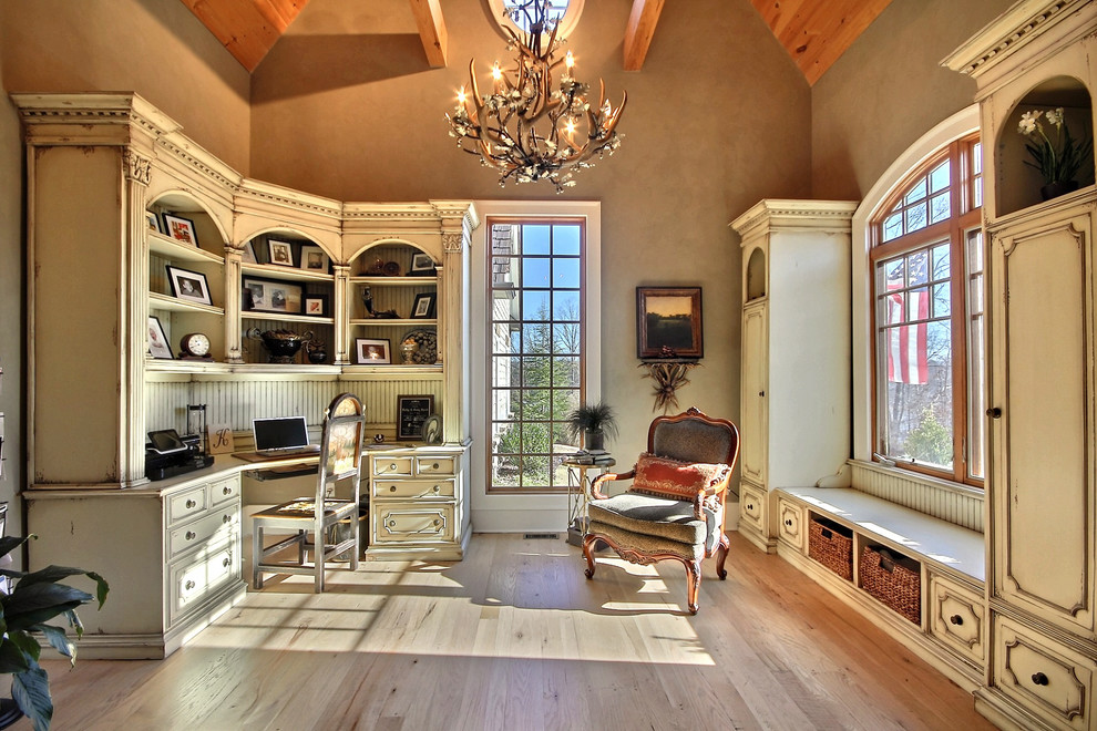 Example of a tuscan built-in desk medium tone wood floor home office design in Atlanta