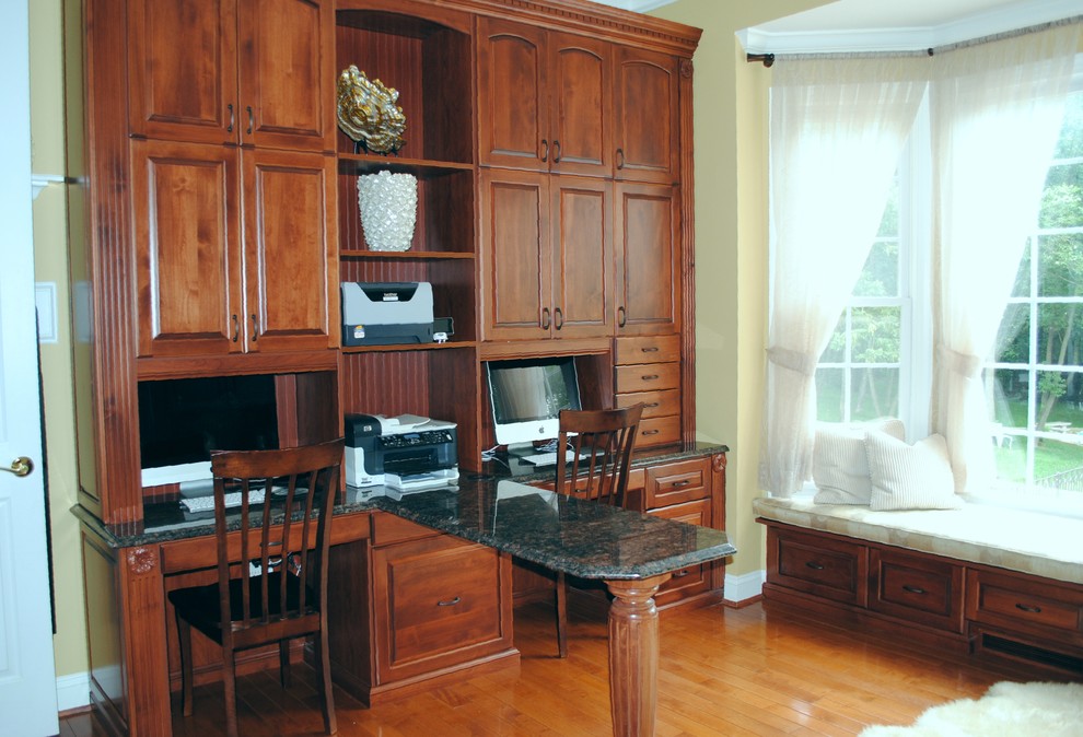 Study room - large traditional built-in desk medium tone wood floor study room idea in DC Metro with yellow walls