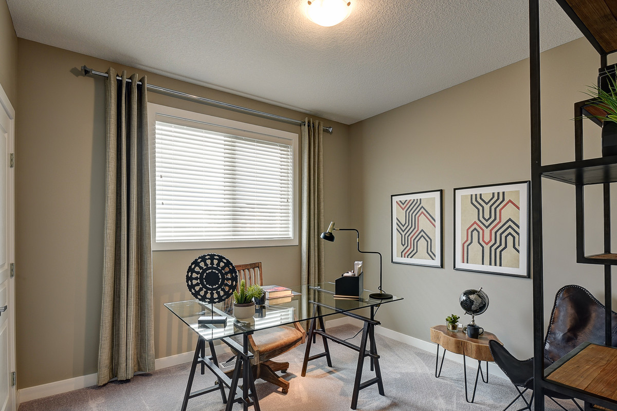 This is an example of a medium sized traditional home office in Calgary with beige walls, carpet, no fireplace, a freestanding desk and beige floors.