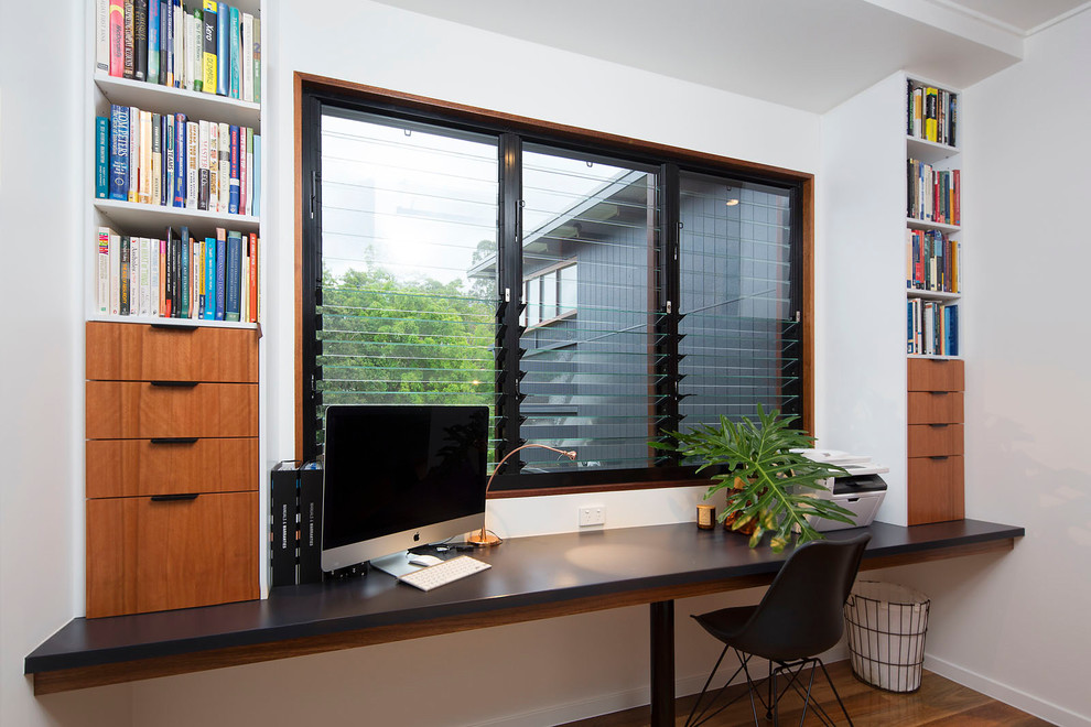 Пример оригинального дизайна: маленький кабинет в стиле модернизм с белыми стенами, паркетным полом среднего тона, встроенным рабочим столом и разноцветным полом для на участке и в саду