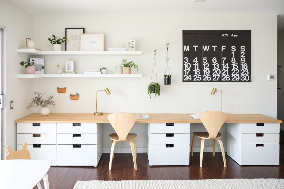 Kleines Modernes Arbeitszimmer ohne Kamin mit weißer Wandfarbe, dunklem Holzboden und braunem Boden in San Diego
