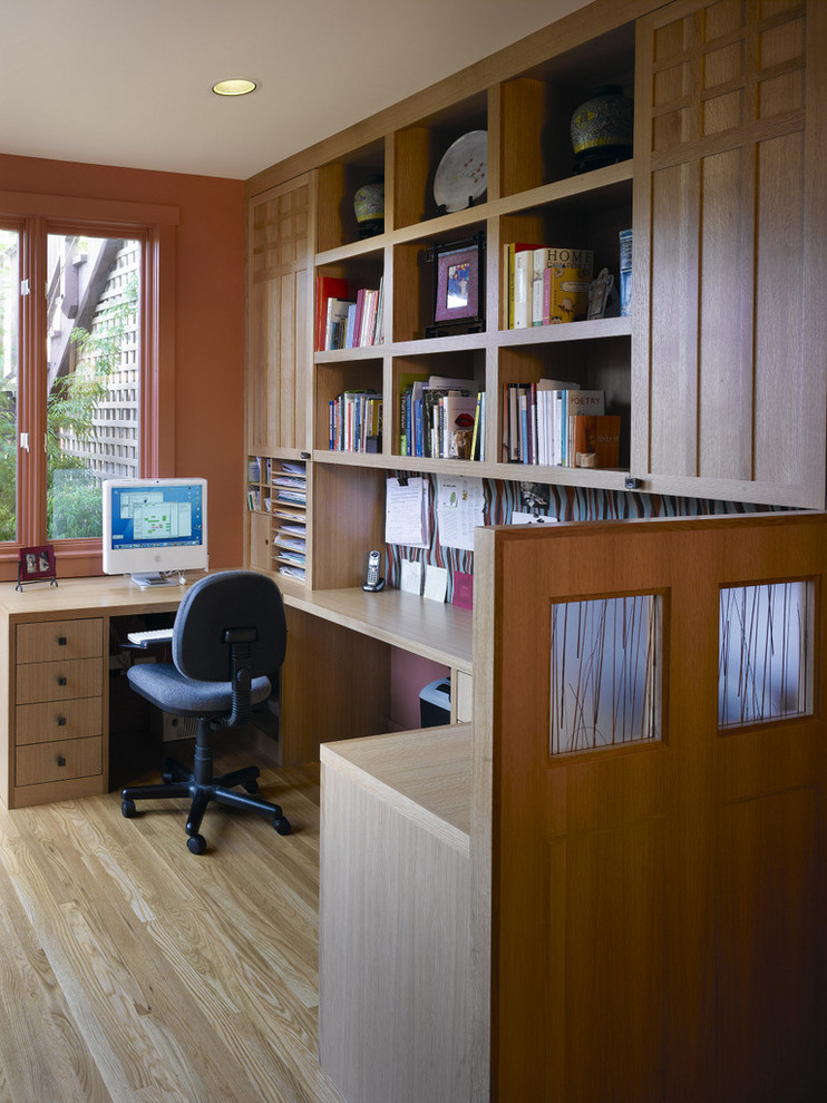 Medium sized world-inspired study in San Francisco with orange walls, light hardwood flooring and a built-in desk.