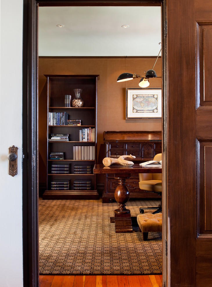 Idéer för att renovera ett mellanstort vintage hemmabibliotek, med bruna väggar, mellanmörkt trägolv och ett fristående skrivbord