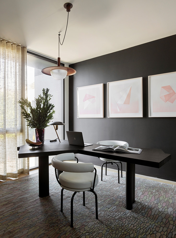 Imagen de despacho contemporáneo con paredes negras, suelo de madera en tonos medios, escritorio independiente y suelo marrón