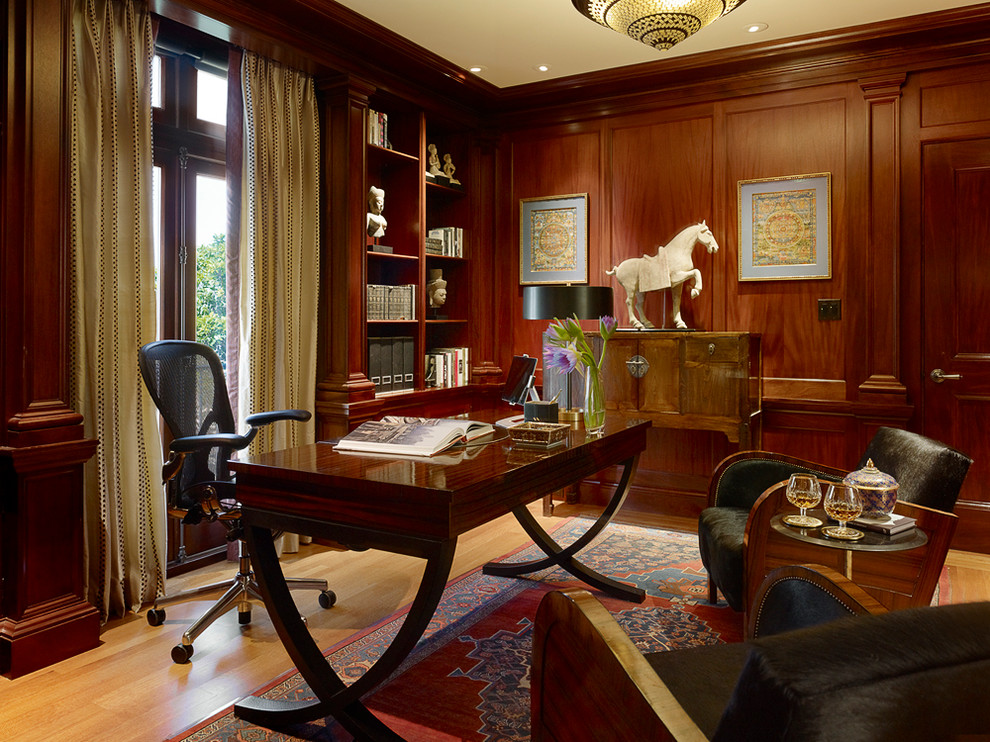 Foto de despacho clásico de tamaño medio con paredes marrones, suelo de madera clara y escritorio independiente