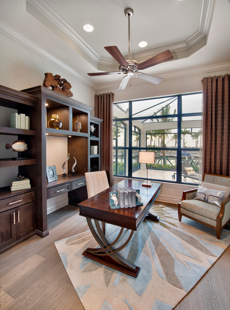 Example of a transitional freestanding desk light wood floor study room design in Miami with white walls and no fireplace
