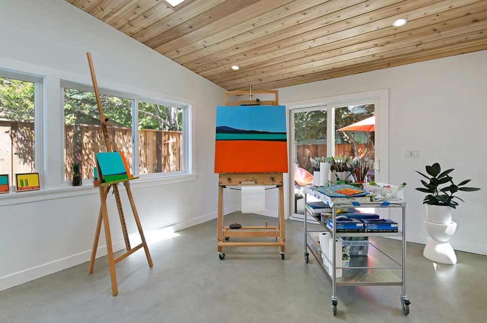 На фото: домашняя мастерская среднего размера в скандинавском стиле с белыми стенами, бетонным полом и серым полом с