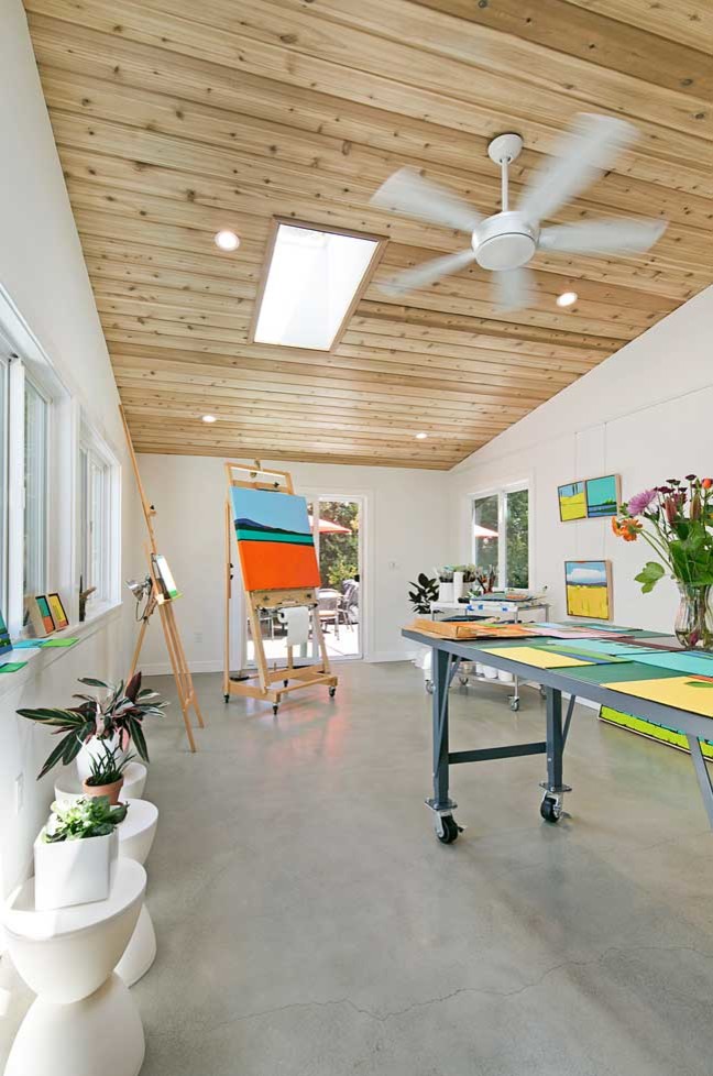 Foto di un atelier scandinavo di medie dimensioni con pareti bianche, pavimento in cemento e pavimento grigio