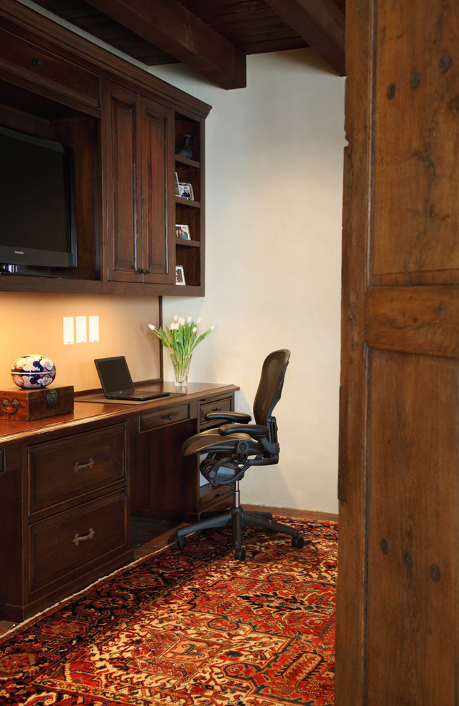 Mid-sized tuscan built-in desk carpeted home office photo in Seattle with beige walls