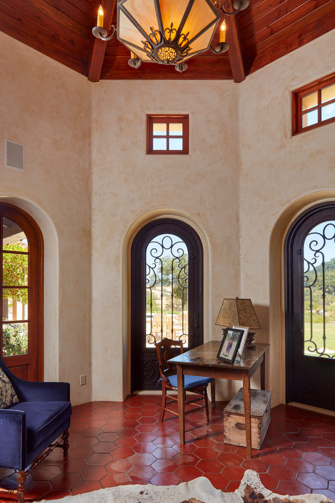 Источник вдохновения для домашнего уюта: кабинет в средиземноморском стиле с бежевыми стенами, отдельно стоящим рабочим столом и красным полом