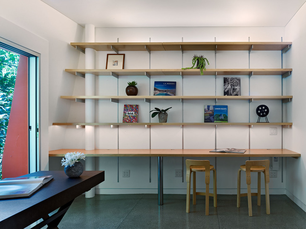 На фото: кабинет в стиле модернизм с отдельно стоящим рабочим столом, белыми стенами и серым полом