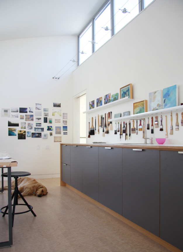 Diseño de estudio minimalista grande con paredes blancas y escritorio independiente