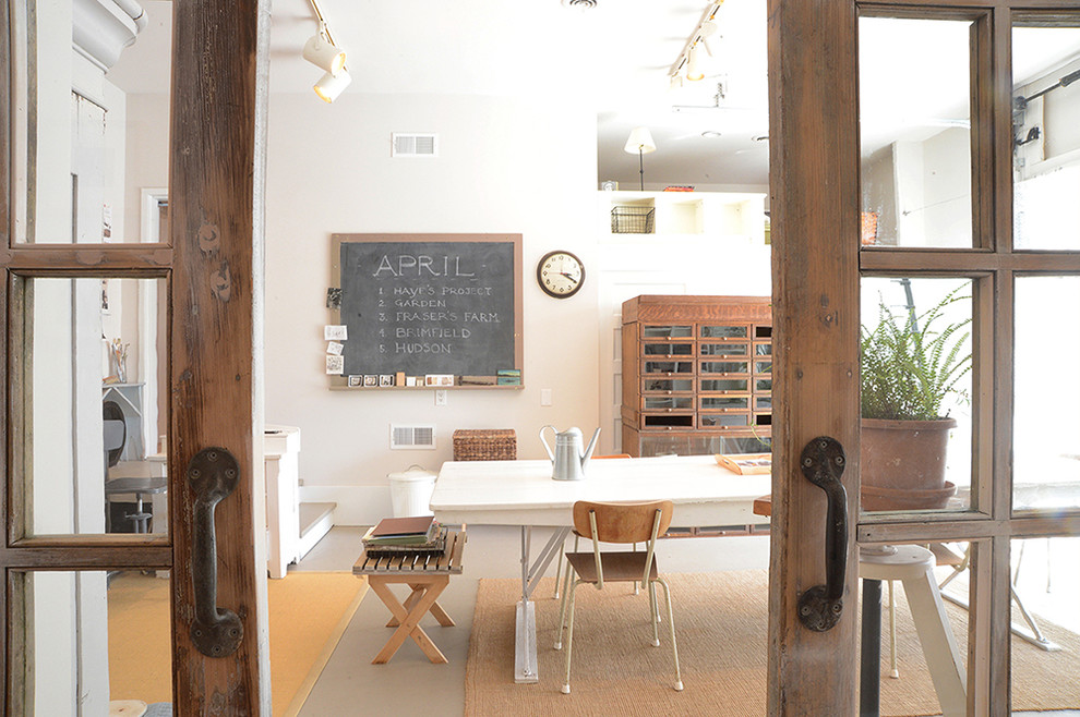 Landhausstil Arbeitszimmer mit Studio, weißer Wandfarbe, Betonboden und freistehendem Schreibtisch in New York