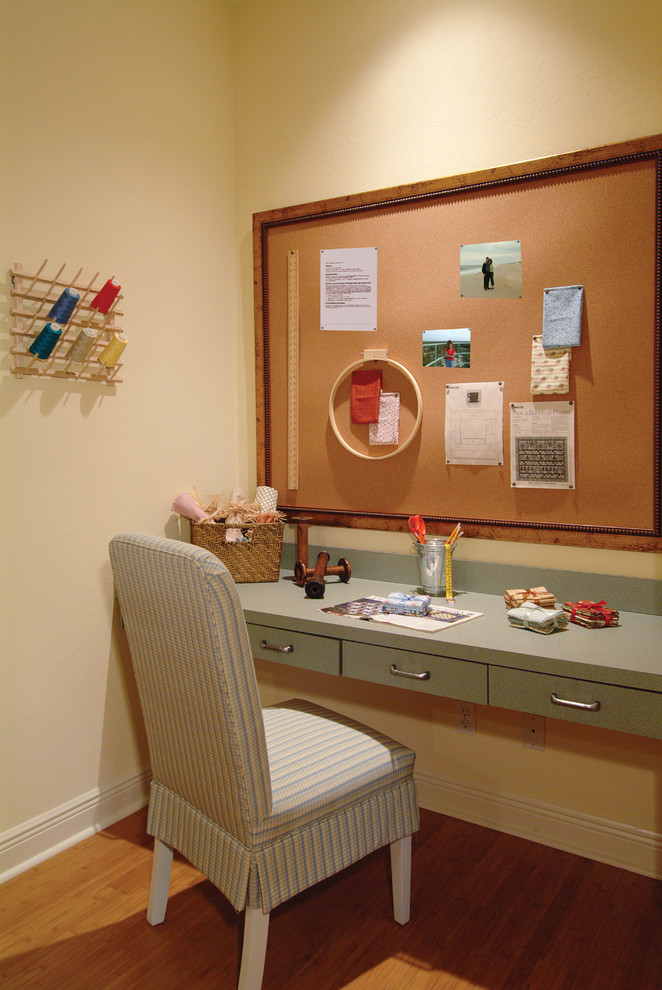 Foto på ett mellanstort lantligt hobbyrum, med mellanmörkt trägolv, ett inbyggt skrivbord och beige väggar