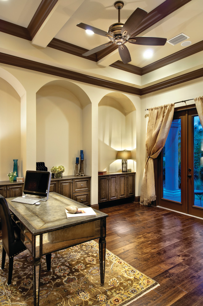 Large mediterranean study in Miami with beige walls, dark hardwood flooring, no fireplace and a freestanding desk.