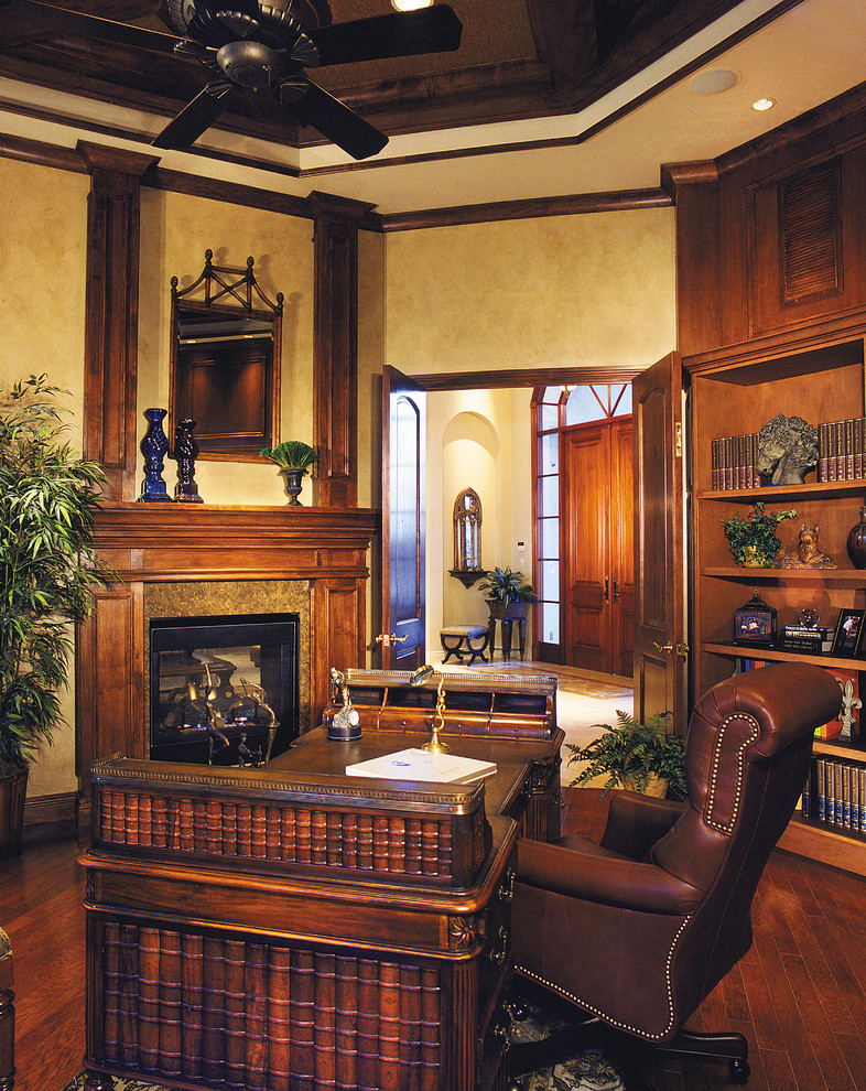 Cette image montre un très grand bureau traditionnel avec un mur beige, parquet foncé, une cheminée standard et un bureau indépendant.