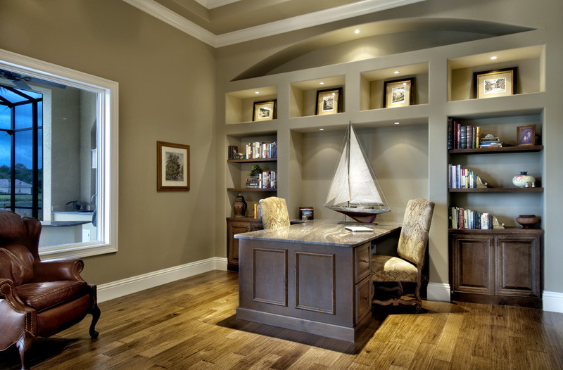 Study room - large mediterranean built-in desk medium tone wood floor study room idea in Miami with green walls and no fireplace