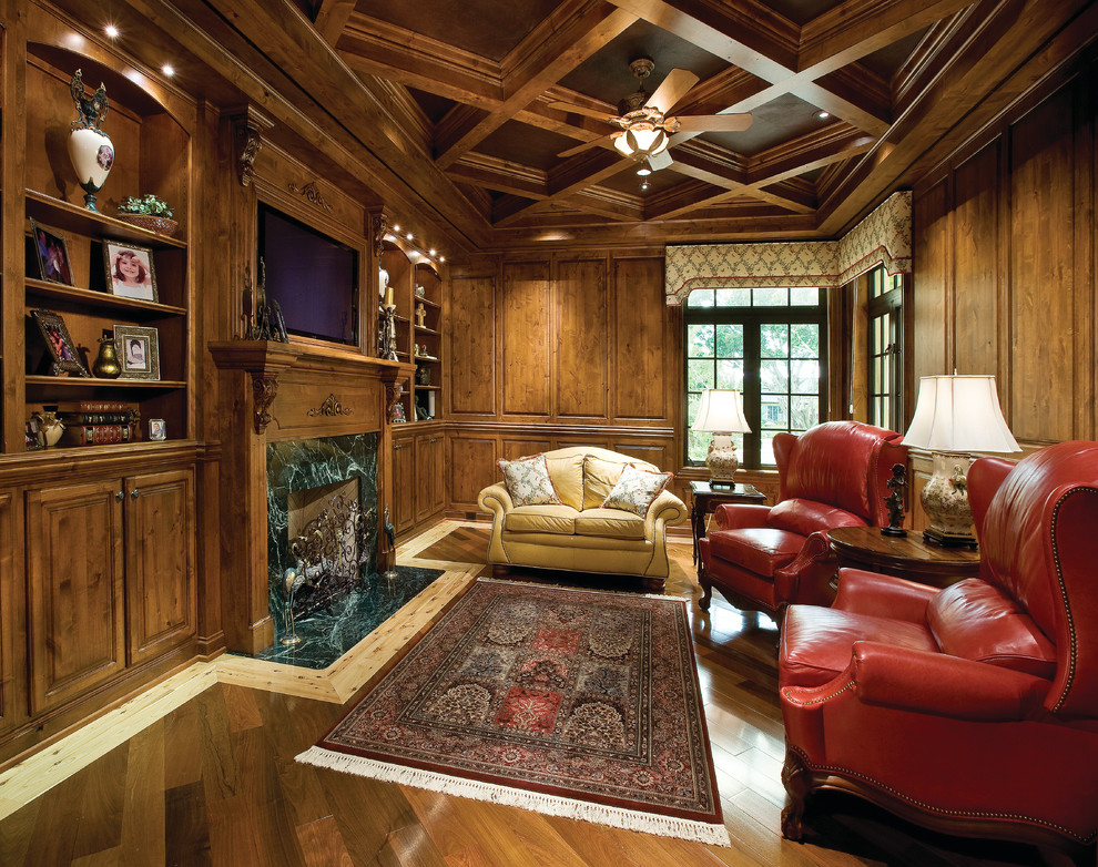 Foto de despacho tradicional grande con paredes marrones, suelo de madera en tonos medios, todas las chimeneas y marco de chimenea de piedra