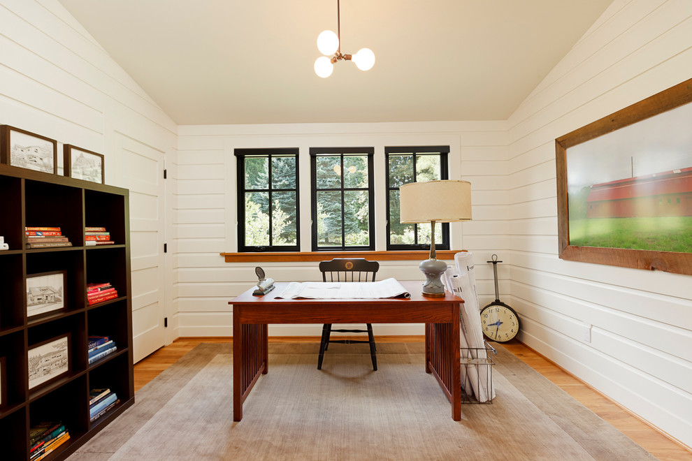 На фото: кабинет в стиле кантри с белыми стенами, паркетным полом среднего тона и отдельно стоящим рабочим столом с