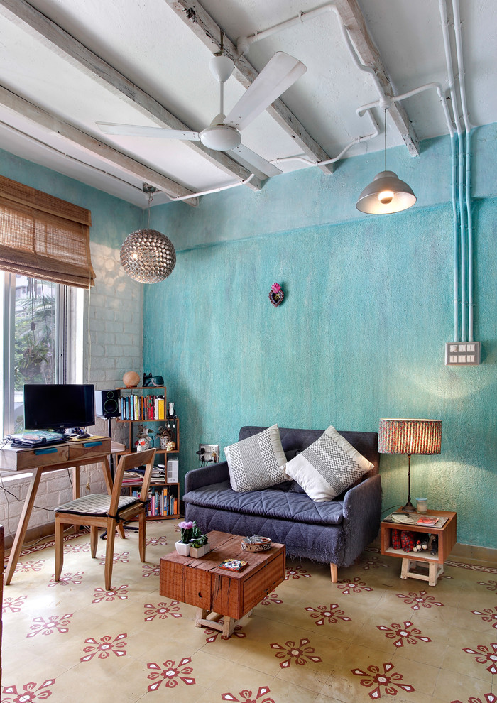 ムンバイにあるインダストリアルスタイルのおしゃれなホームオフィス・書斎 (ライブラリー、自立型机、青い壁、マルチカラーの床) の写真