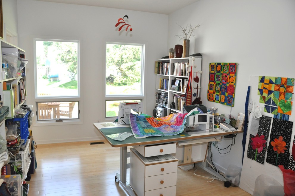 Imagen de despacho de estilo de casa de campo pequeño con paredes blancas, suelo de bambú y escritorio independiente