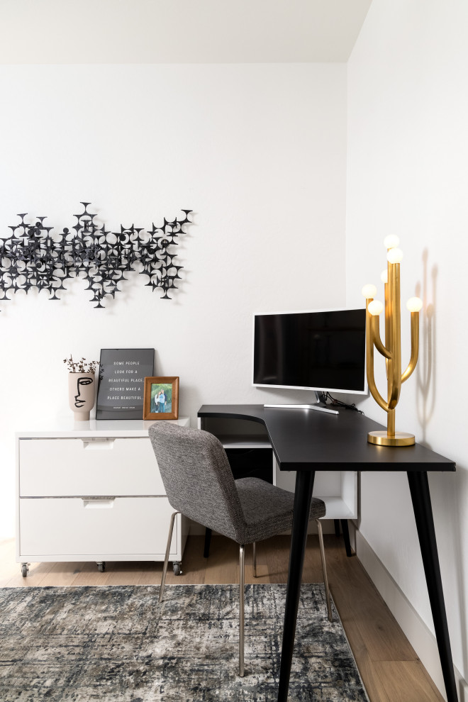 This is an example of a scandi home office in Phoenix with white walls, medium hardwood flooring, a freestanding desk and brown floors.