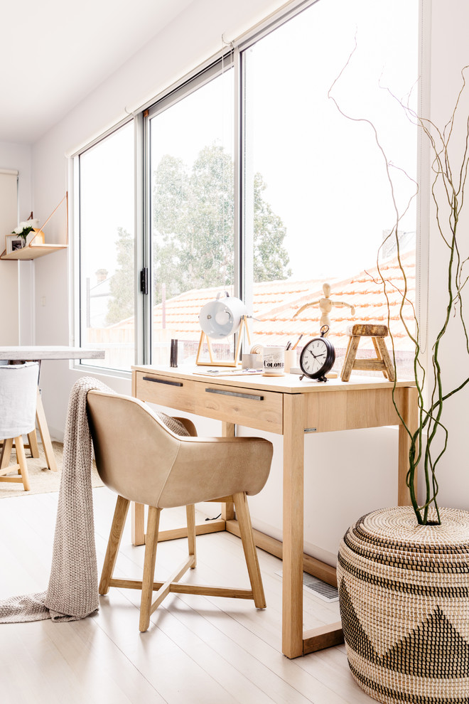 Nordisches Arbeitszimmer mit weißer Wandfarbe, hellem Holzboden und freistehendem Schreibtisch in Melbourne