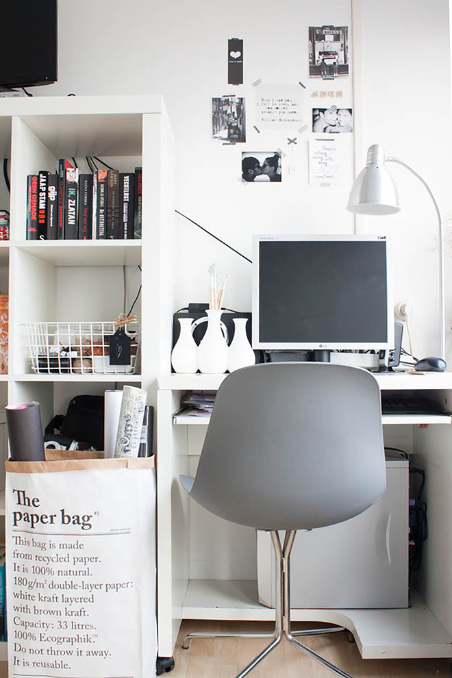 Small scandinavian home office in Amsterdam with white walls, light hardwood flooring and a freestanding desk.