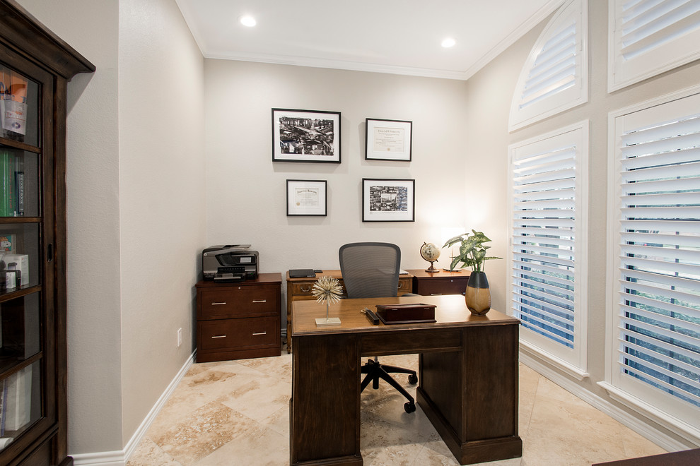 Imagen de despacho clásico renovado de tamaño medio sin chimenea con paredes grises, suelo de travertino, escritorio independiente y suelo beige