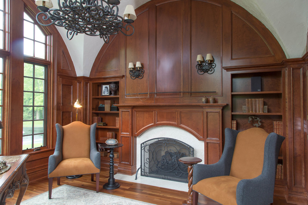 Photo of a medium sized study in Chicago with dark hardwood flooring, a standard fireplace, a wooden fireplace surround and a freestanding desk.