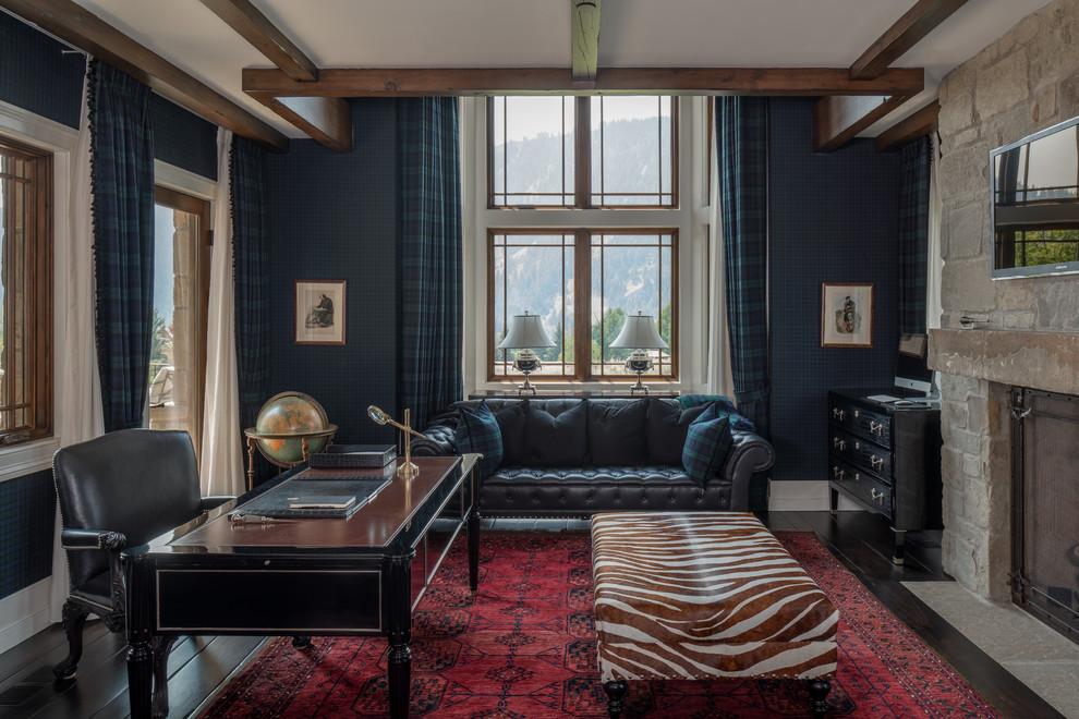 На фото: кабинет в классическом стиле с синими стенами, темным паркетным полом, стандартным камином, фасадом камина из камня, отдельно стоящим рабочим столом и коричневым полом