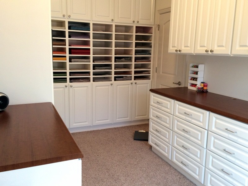 Cette image montre un grand bureau atelier design avec un mur beige, moquette et un bureau intégré.