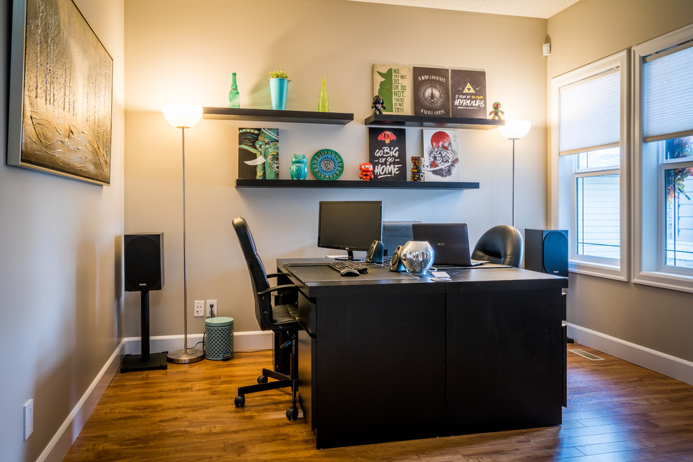 Ejemplo de despacho clásico renovado de tamaño medio sin chimenea con paredes grises, escritorio independiente, suelo marrón y suelo de madera oscura