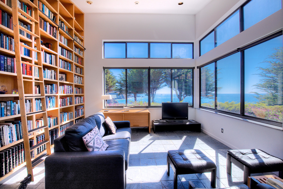 Inspiration för stora moderna hemmabibliotek, med vita väggar, heltäckningsmatta och ett fristående skrivbord
