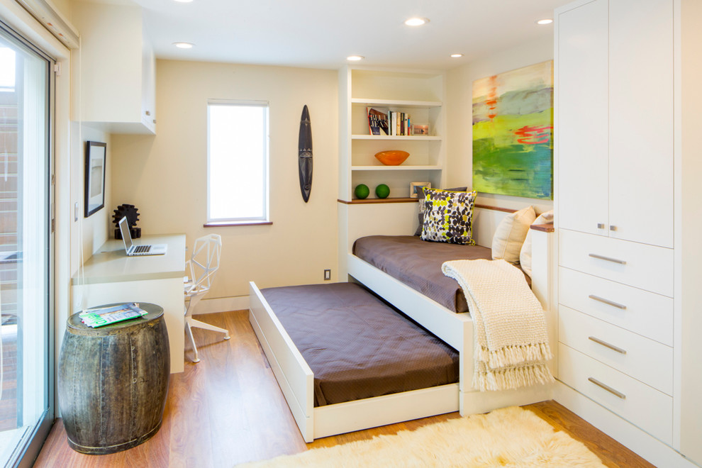 Trendy freestanding desk medium tone wood floor home office photo in San Francisco with beige walls