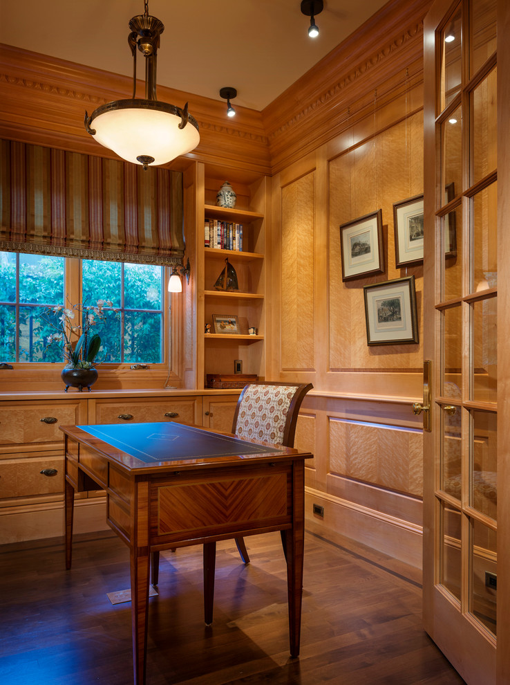 Réalisation d'un bureau tradition avec un sol en bois brun et un bureau indépendant.