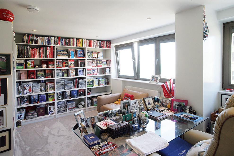 Exempel på ett mellanstort modernt hemmabibliotek, med vita väggar, heltäckningsmatta, ett fristående skrivbord och beiget golv